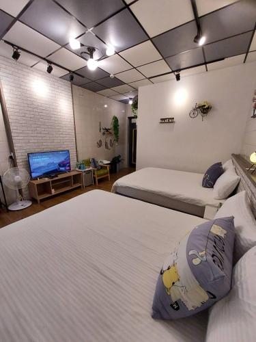 a room with two beds and a flat screen tv at 鹿鹿咪民宿 in Lugang