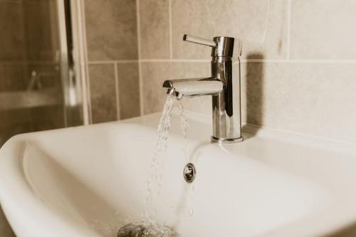 a sink with water coming out of a faucet at The Sun Deck Apartment - Westbrook Bay Beach - By Goldex Coastal Breaks in Kent