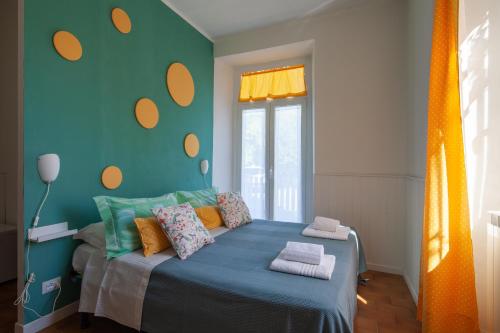 1 dormitorio con 1 cama de color naranja y azul en B&B Il Tempo Del Vento-Camere e Appartamenti, en Tresana