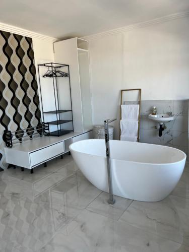 Un baño blanco con una bañera grande y un lavabo. en Sibani@ Dolphin coast, en Ballito