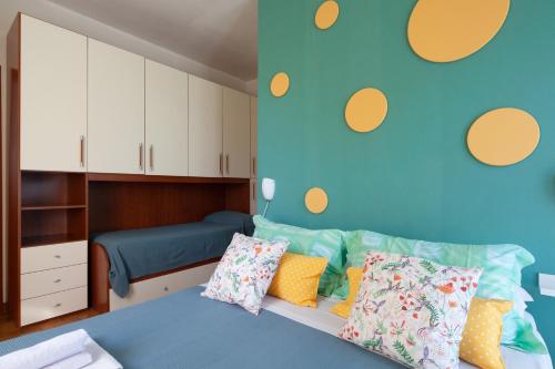 a bedroom with a blue bed with colorful pillows at B&B Il Tempo Del Vento in front of the Castle in Tresana