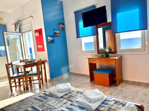 a bedroom with a bed and a desk and a table at Panorama Melina Apartments in Kastrí