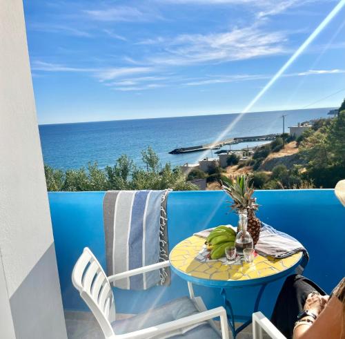 a table on a balcony with a view of the ocean at Panorama Melina Apartments in Kastrí