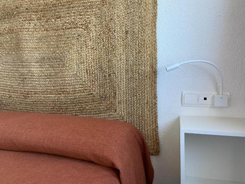 a corner of a bedroom with a bed and a table at Carpe Diem Cadaqués in Cadaqués