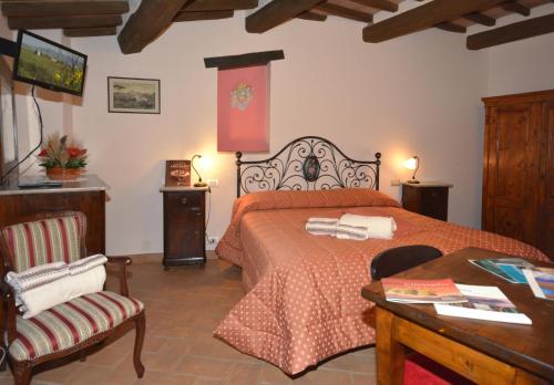 1 dormitorio con 1 cama, 1 mesa y 1 silla en B&B Camere La Vite en Pienza