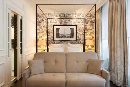 un salon avec un canapé en face d'un mur dans l'établissement Hôtel Keppler, à Paris