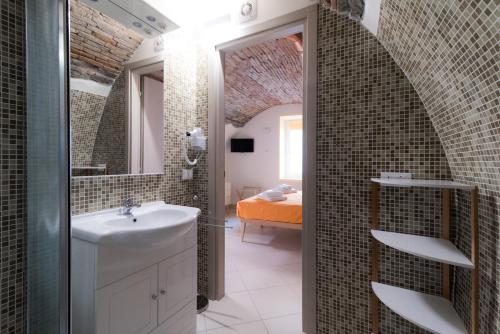 ein Bad mit einem Waschbecken und einem Spiegel in der Unterkunft La casa dei tre pesci - Appartamento Alborella in Torno