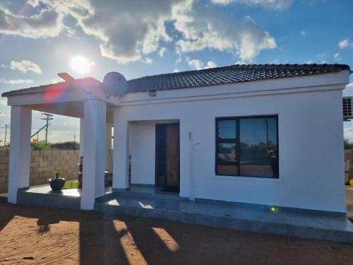 a small white house with a rainbow on the roof at Casa-Pel Guest Wing in Palatswe