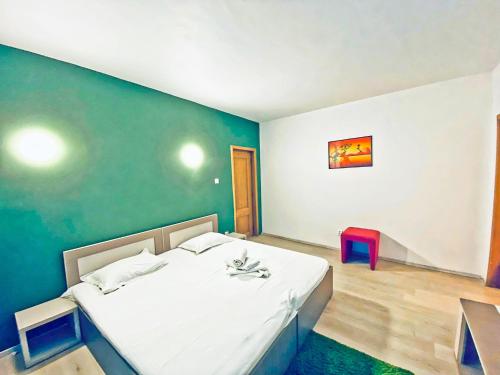 a bedroom with a white bed and a green wall at Royal Accommodation in Bucharest