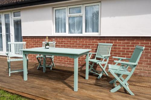 a picnic table and chairs on a deck at Mill House Bungalow in Potter Heigham