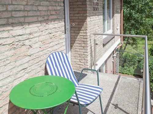 - une table verte et 2 chaises sur la terrasse dans l'établissement Dangaster Nest, Ap Maje, FeWo Vermittlung Nordsee, à Dangast