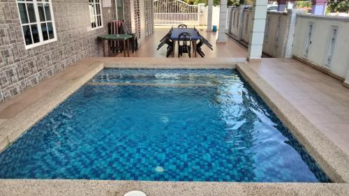 a swimming pool with blue water in a house at Dorry Villa 2226 in Port Dickson