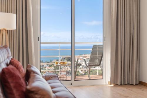 a living room with a couch and a sliding glass door at Garajau VI by An Island Apart in Santa Cruz