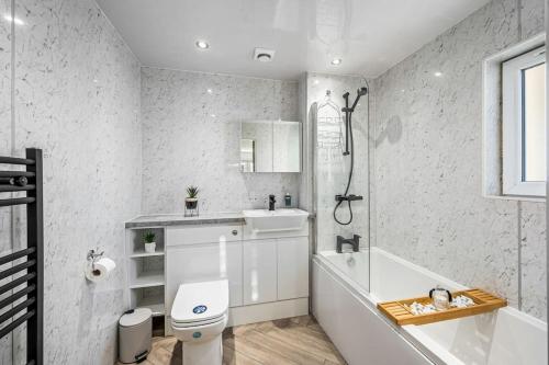 ein Badezimmer mit einer Badewanne, einem WC und einem Waschbecken in der Unterkunft Luxury Apartment with Sea Views in Arbroath