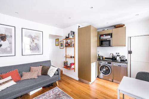 un salon avec un canapé et une cuisine dans l'établissement Ciseaux 4G - SAINT GERMAIN DES PRÈS - Best Location, à Paris