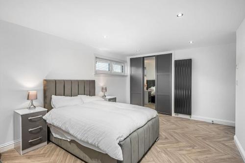 a bedroom with a large bed and a night stand with a lamp at Sea View Luxury Apartment 3 bedrooms Free Parking - By Coast Apartments in Arbroath