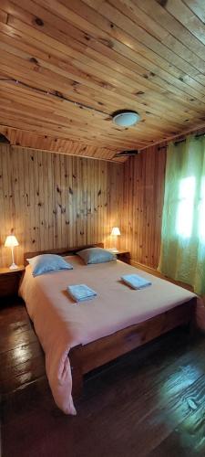 a large bed in a room with a wooden ceiling at Gite Ti Case Lontan in Cilaos