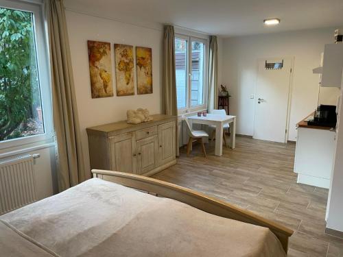 Zimmer mit einem Bett und einem Tisch sowie einer Küche in der Unterkunft Tolles Apartment in idyllischer ruhiger Lage in Braunschweig