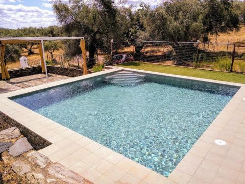 una piscina de agua azul en un patio en Finca el Berezal, en Aracena
