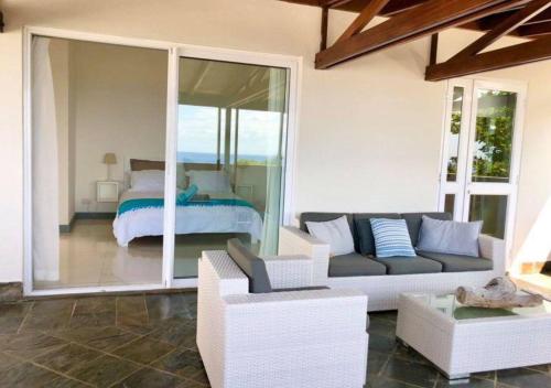 a living room with a couch and a bed at Frangipanier 2 bedrooms Sea view Penthouse in Trou aux Biches