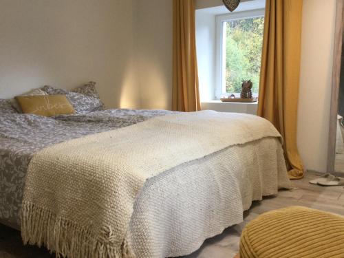 a bedroom with a bed with a white blanket and a window at Accomodatie in Villa Werschmatt in Kruth