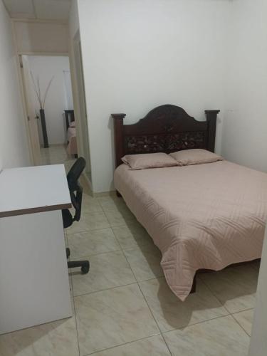 1 dormitorio con cama y escritorio en Apartaestudio, en Santa Marta