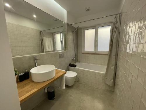 uma casa de banho com um lavatório, uma banheira e um WC. em ASF Home em Lisboa