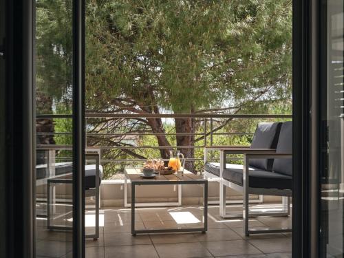 patio z 2 krzesłami, stołem i oknem w obiekcie La Palma Apartment w mieście Zakintos