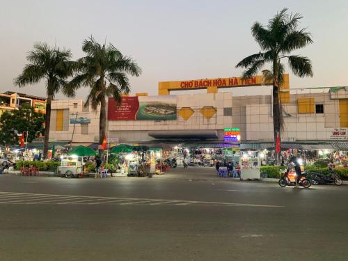 une rue en face d'un bâtiment avec des palmiers dans l'établissement Khách Sạn Tú Anh, à Hà Tiên