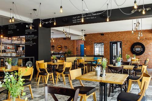 a restaurant with wooden tables and chairs and a brick wall at Dubno Eat & Sleep in Nová Dubnica