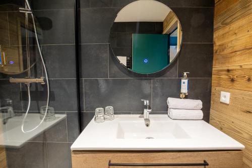 un baño con lavabo y espejo en Hotel Les Lutins, en Les Deux Alpes