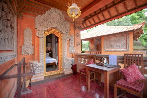 a room with a table and a mirror and a bedroom at Gayatri in Ubud