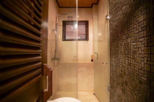 a bathroom with a shower stall and a toilet at Gayatri in Ubud