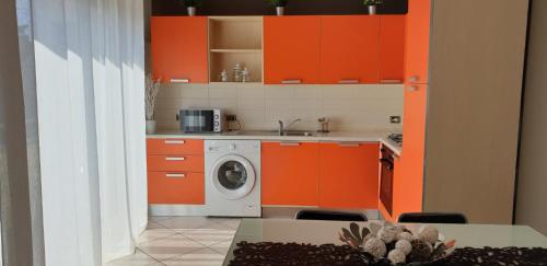 a kitchen with orange cabinets and a washing machine at Hotel Residence Aurora in Paderno Dugnano