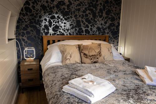 a bedroom with a bed with towels on it at Hollins Farm - Dog Friendly, Self Catering Holiday Lodges in Knaresborough