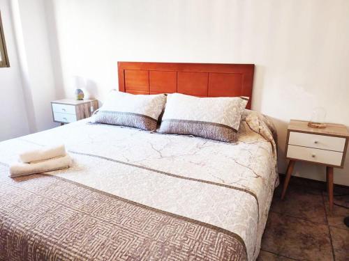 a bedroom with a large bed with a wooden headboard at La Encina in Alhama de Granada