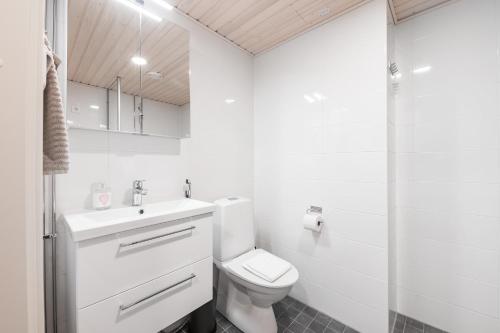 a white bathroom with a toilet and a sink at Forenom Serviced Apartments Jyväskylä Vaasankatu in Jyväskylä
