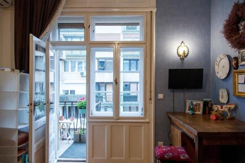 Habitación con una puerta que da a un balcón. en Blumen Apartment, en Budapest