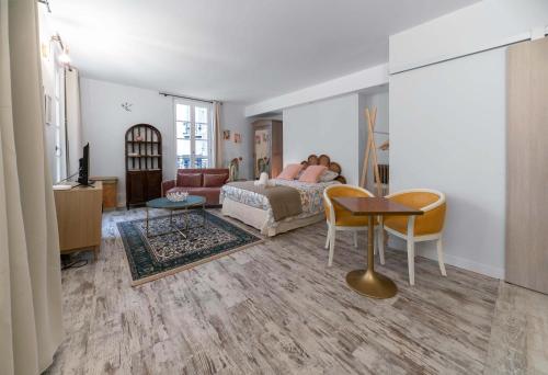 a woman laying on a bed in a living room at Résidence Aristide Briand - Appartements en Centre Ville in Vichy