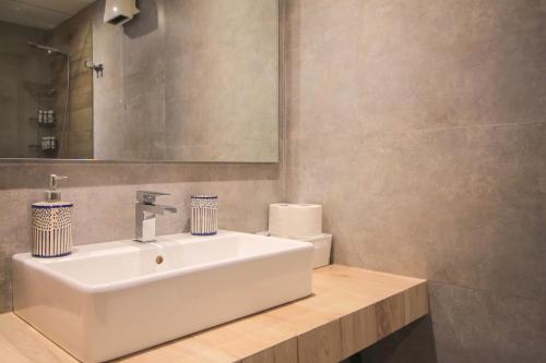 a bathroom with a white sink and a mirror at Tinos Pigeon House by TinosHost in Tzádhos