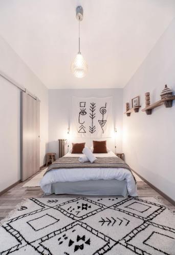 a bedroom with a bed and a rug on the floor at Résidence Aristide Briand - Appartements en Centre Ville in Vichy