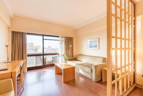 uma sala de estar com um sofá e uma mesa em Hotel Roma em Lisboa