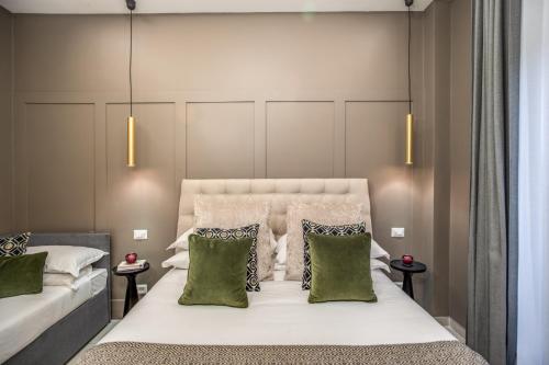 ローマにあるBorgognona Roomsのベッドルーム(緑の枕が付く大きな白いベッド付)