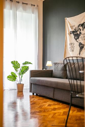 a living room with a couch and a plant at Home Out Rooms & Apartments in Lisbon