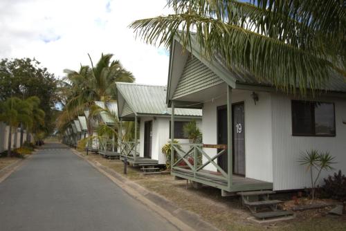a row of houses on a street with palm trees at Central Tourist Park in Mackay