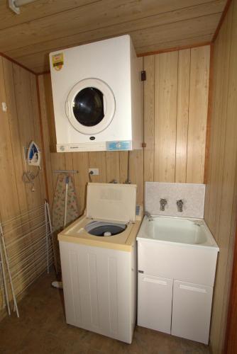 a small bathroom with a sink and a washing machine at Central Tourist Park in Mackay