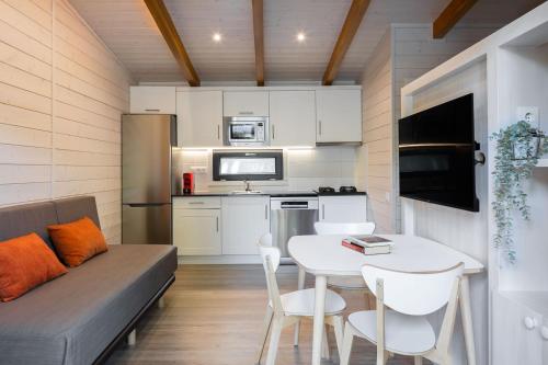 a small kitchen with a white table and a couch at Càmping Vall De Camprodon in Camprodon