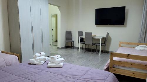a room with two beds and a tv on the wall at Binario176 in Ercolano