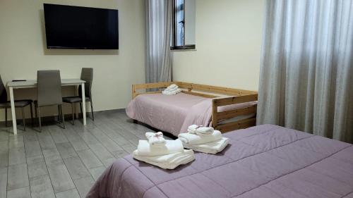 una camera d'albergo con due letti e asciugamani di B&B binario176 a Ercolano