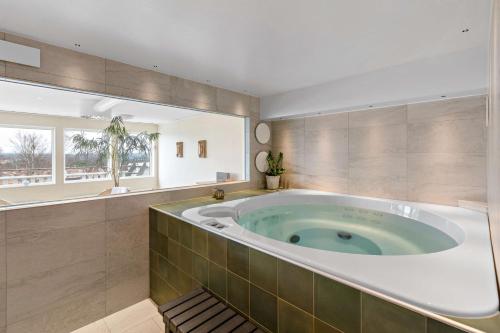 uma grande banheira numa casa de banho com uma janela em Best Western Hotell Lerdalshoejden em Rättvik